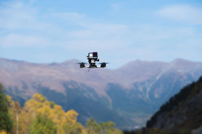 Drone with an action camera films mountains in flight. close-up of an unmanned device, fpv with