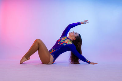 Full length of young woman doing yoga on stage