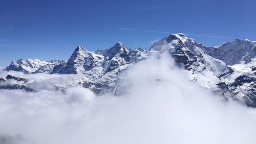 Snowcapped mountains against clear blue sky