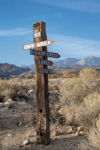Wooden road sign with wood arrows in desert mountain landscape 