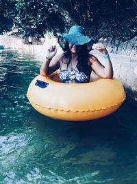 Woman sitting with pool raft in swimming pool