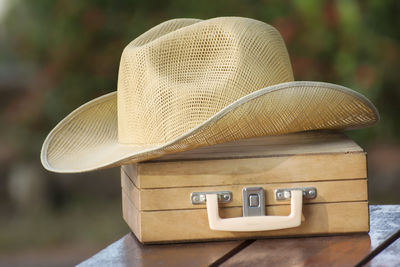 Close-up of hat on wooden box at table