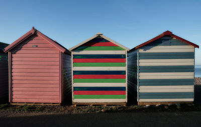 Multi colored houses on beach against sky