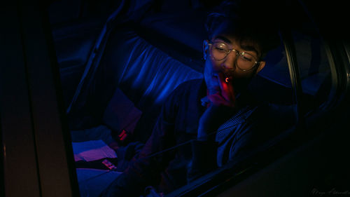 Portrait of young man looking away at night