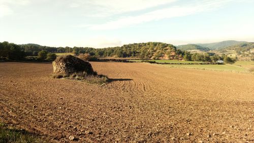 Hay bales on field against sky