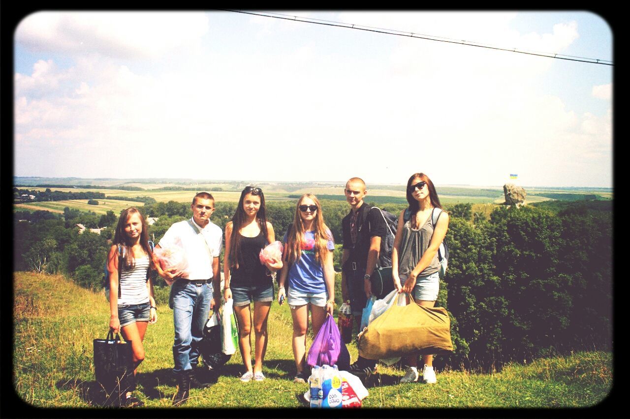 transfer print, lifestyles, leisure activity, grass, men, sky, auto post production filter, person, field, large group of people, togetherness, landscape, horizon over water, nature, casual clothing, sea, standing, water