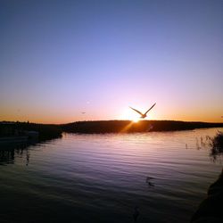 Scenic view of lake against clear sky during sunset