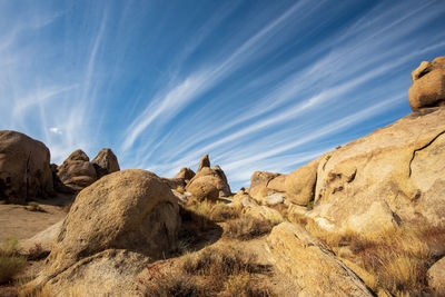 Desert rock formations with streaky clouds in blue sky
