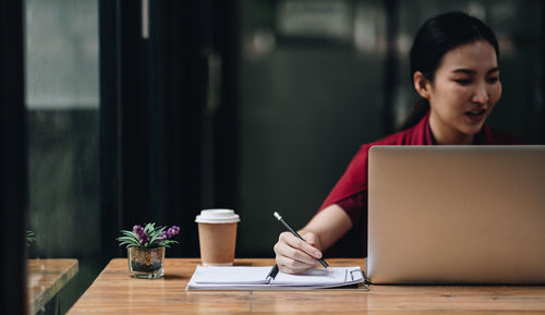 Young woman using laptop at table