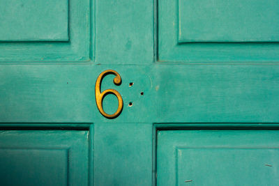 House number sixty something with missing second digit on a turquoise wooden front door in london