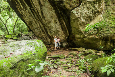 Full length of man standing on rock in forest