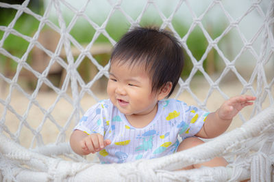 Cute baby girl looking through fence