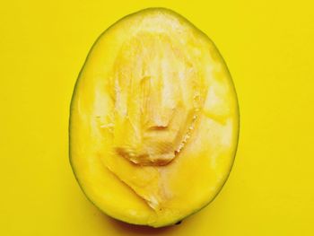 High angle view of lemon slice against yellow background