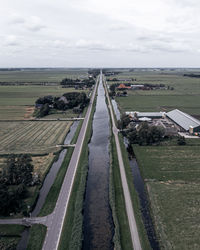 Panoramic shot of road amidst field against sky