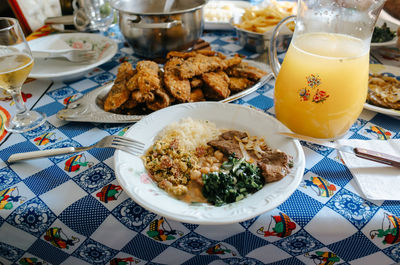 Plate with beans, rice and beef and a carafe of orange juice