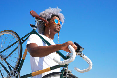 Afro and black man carrying a city bike on his back. black rider and cyclist concept. cycle through the city.