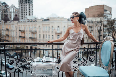 Full length of woman on railing in city