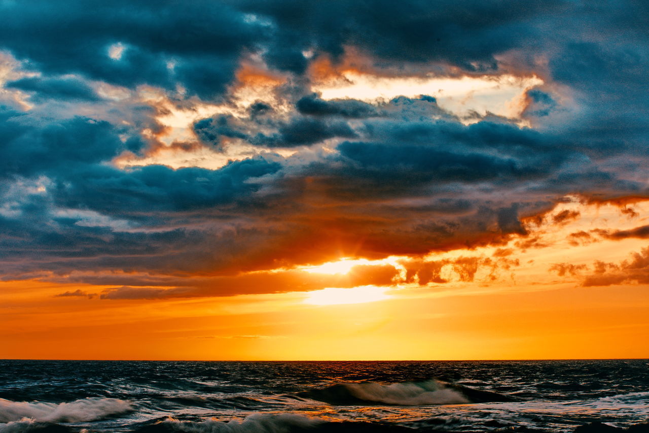 SCENIC VIEW OF SEA AGAINST DRAMATIC SKY AT SUNSET