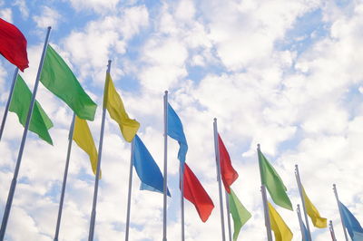 Low angle view of colorful flags against sky