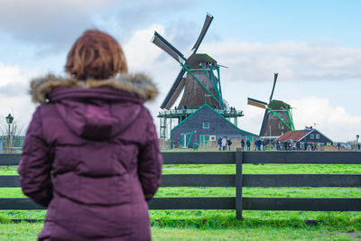 Rear view of woman on field against sky