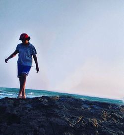 Full length of boy on beach against sky