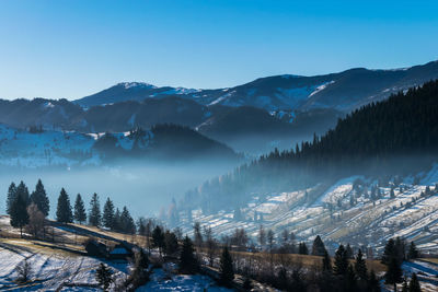 Scenic view of mountains against blue sky at dawn