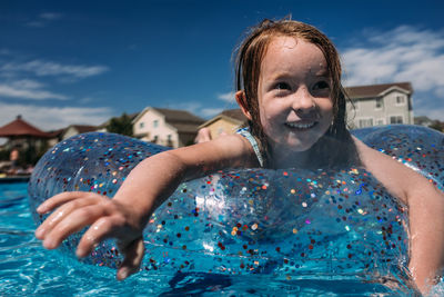 Close up of young girl swimming in pool on a round float