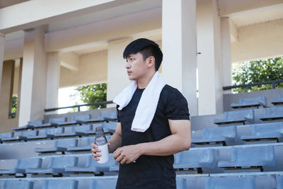 Full length of a young man standing against built structure