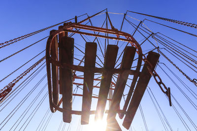 Low angle view of crane against clear blue sky