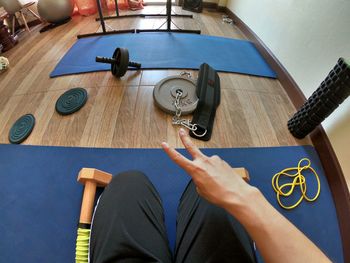 High angle view of man holding hands on table at home