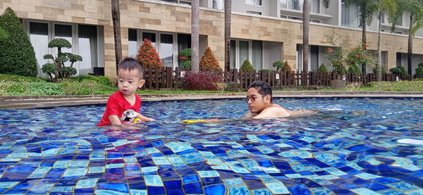 Full length of shirtless boy swimming in pool