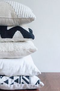 Close-up of cushions stacked on table against wall