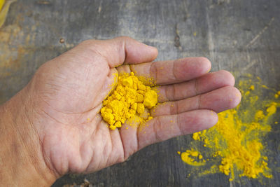 Close-up of hand holding yellow flower