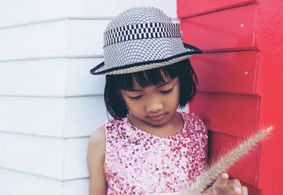 Cute girl looking away against wall