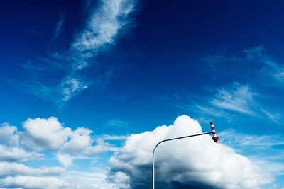 Low angle view of arrow symbol against blue sky