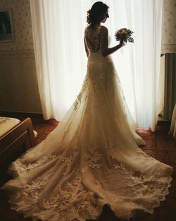 Bride wearing dress standing at home