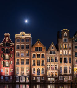 Low angle view of illuminated buildings against sky at night