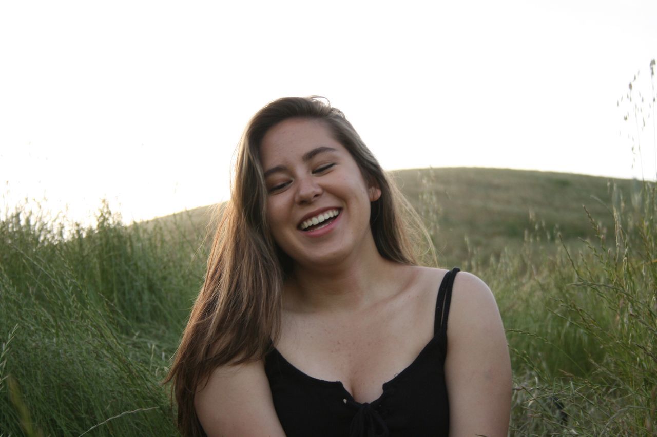 real people, young adult, young women, front view, one person, leisure activity, nature, lifestyles, grass, field, smiling, outdoors, happiness, day, beautiful woman, clear sky, sky