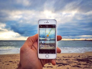 Cropped image of woman photographing through smart phone