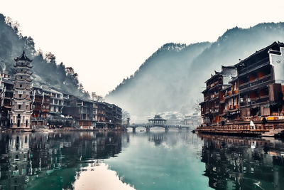 Reflection of buildings in city at waterfront