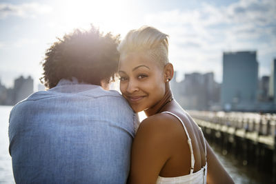 Portrait of woman standing with man against sky