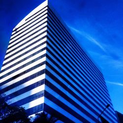 Low angle view of modern building against blue sky