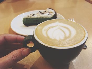 Close-up of hand holding coffee cup