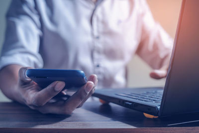 Midsection of man using mobile phone