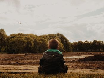 Rear view of man sitting on bench