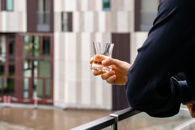 Midsection of man drinking glass