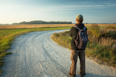 Rear view of man on road against sky