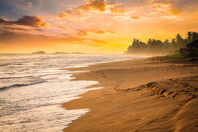 Scenic view of beach against sky during sunset