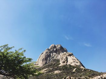 Scenic view of mountain against blue sky