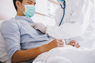 Midsection of woman lying on bed